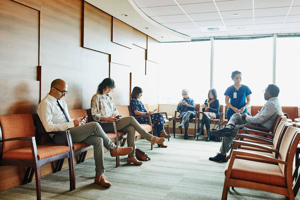 Nurse greeting patient in medical office waiting room